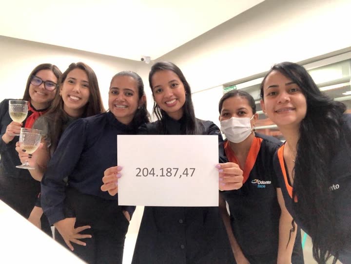 Foto da equipe segurando o papel '204.187,47'