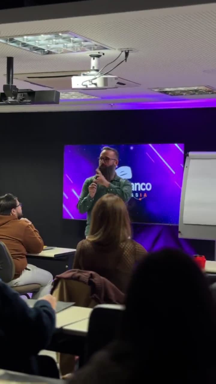 A turma sentada na sala, com o telão ao fundo